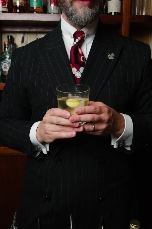 Tailored suit with a cocktail in hand