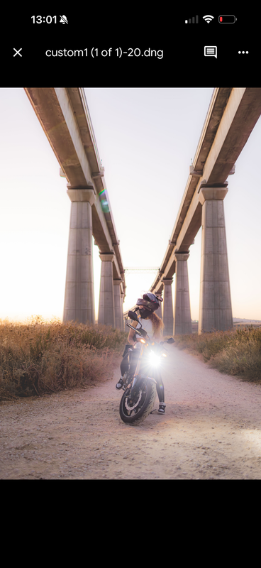 Motorcycle rider under the bridge at dusk