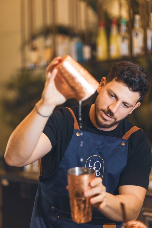 Bartender shaking a cocktail behind the bar